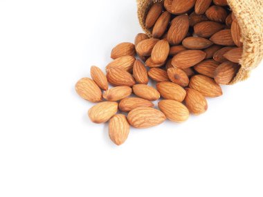 Badem tohumları beyaz arka planda izole edilmiş çuval bezi poşetinde. Sağlıklı yemek.