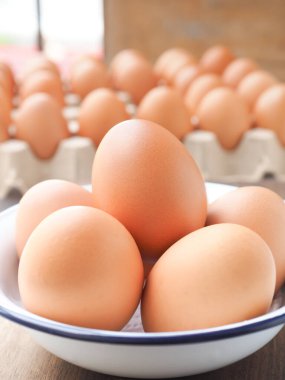 Çiftlikten taze organik yumurtaları ahşap arka planda beyaz bir kâse içinde kapayın. Protein bakımından yüksek, kopyalama alanı ile