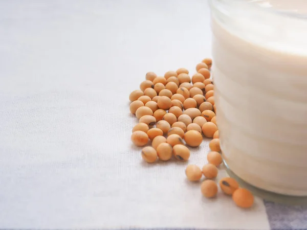 白い生地の上に豆乳の大豆とガラス 植物タンパク質 テキストのコピースペース — ストック写真