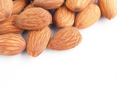 Beyaz arka planda izole edilmiş organik badem tohumları. Üst görünüm.  