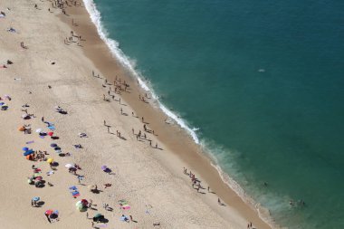 Nazar güneşli plajda Mountan görünümü, Portekiz.