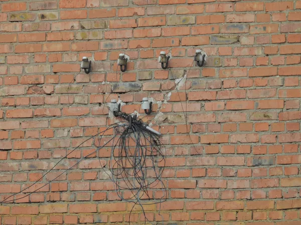 sarkan elektrik teli bir bobin ile terk edilmiş bir binanın tuğla duvar