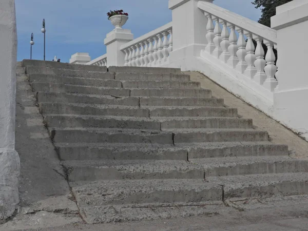 bir şehir parkı yaz gününde beyaz boyalı beton korkuluklar ile adımlar