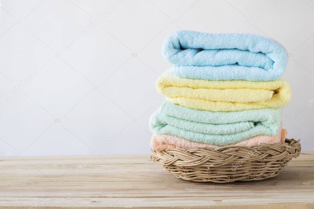 towel on basket on wood table with white wall and copy space, can be used for present products