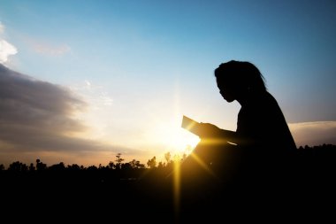 Okuma ve kavramı, kadınlar sit silüeti rahatla ve gün batımı kitap okumak