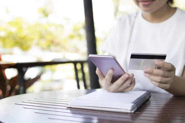 Women use phone for mobile banking with credit card to online shopping concept