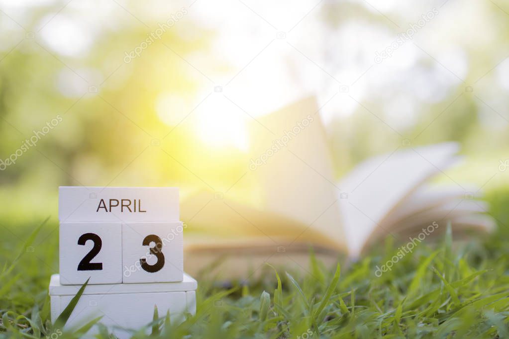 23, april of reading day, book opening on green grass, knowledge and education concept