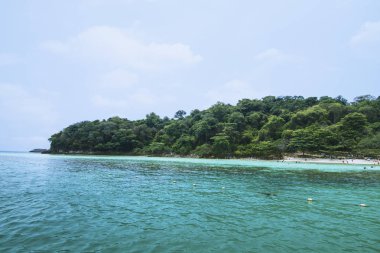 Tayland 'da mavi su, gökyüzü ve beyaz bulut manzaralı bir ada.
