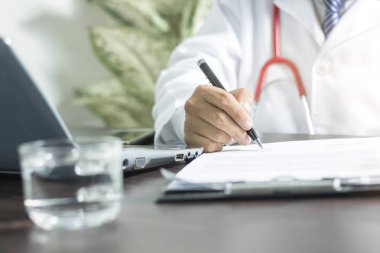 Doktorun hastaya sağlık sigortası için klinikteki ilaç kağıtlarına bilgi yazması