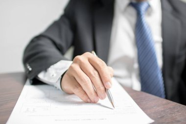 İşadamı veya avukat sözleşme imzalamadan önce sözleşmeyi dikkatle okumak niyetinde.