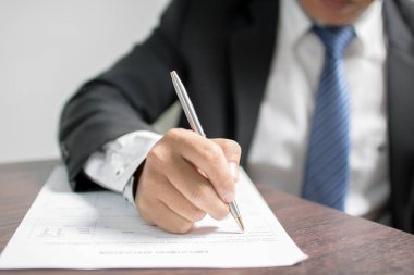 İş adamı başvuru formuna yazı yazıyor ve iş için iş görüşmesi bekliyor.