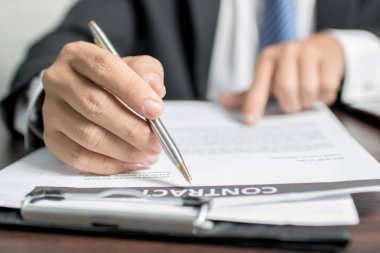 İşadamı veya avukat sözleşme imzalamadan önce sözleşmeyi dikkatle okumak niyetinde.