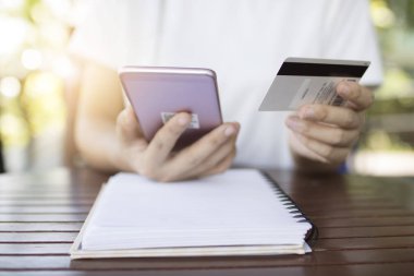 Kadınlar cep telefonu bankacılığı için kredi kartıyla online alışveriş için telefon kullanırlar.