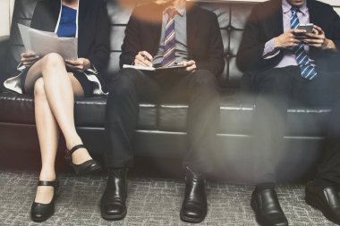 kanepede oturan ve röportaj için bekleyen iş adamları