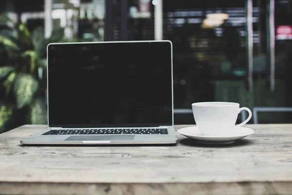 咖啡厅木桌上的咖啡和笔记本电脑 — 图库照片