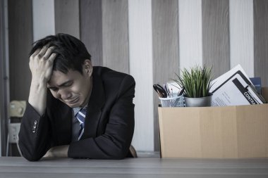 İşsiz ve üzgün bir adam ofiste oturup ağlıyor, iş adamı serbest bırakıldıktan sonra çalışma masasını hazırlıyor ya da işi iptal ediyor.