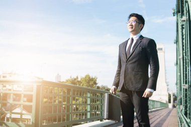 Gizli iş adamı ayakta ve çantasını tutuyor, yatırımcı yürüyor ve ileriye bakıyor. 