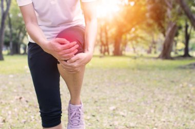 Kadınların parkta egzersiz olarak diz ağrısı vardır.