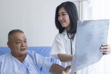 Doktor röntgen filmi gösteriyor ve hastalıkları anlatıyor