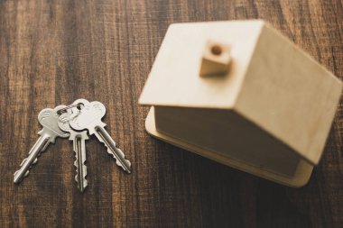 Emlak konsepti, masadaki ev anahtarı ve ev modelinin üst görünümü