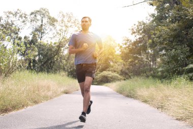 Koşucu adam parkta koşar, egzersiz yapar ve konsepti geliştirir. 
