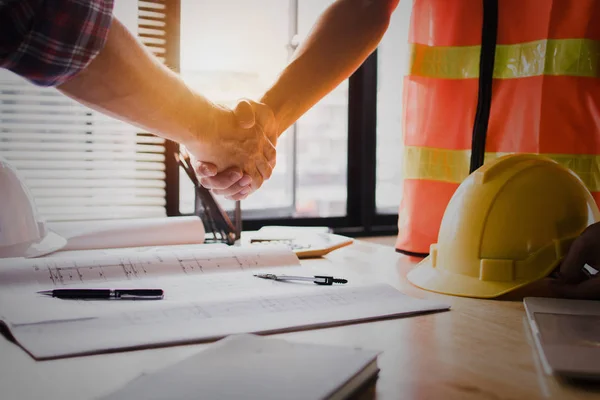 Real estate concept, architect shake hands with engineer or constructor worker, successful planning and meeting about home, house and resident construction