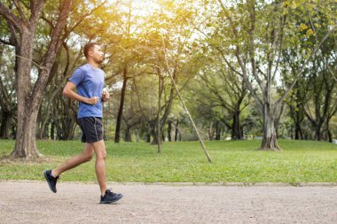 Koşucu adam parkta koşar, egzersiz yapar ve konsepti geliştirir. 