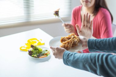 diet woman eateing fresh vegetable and  reject chicken meal 