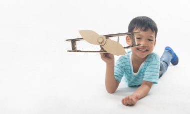 kid dreams as pilot laying and holding airplane paper isolated o
