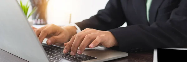 Close up businesswoman  in suite using laptop computer. Female working on laptop on working table