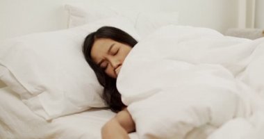 Depresyondaki genç Asyalı Taylandlı kadın yatağa uzandı yatak odasında stres hissetti, endişeli melez kadın sabahları uykusuzluk çekiyor.