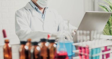 Örtülü Araştırma Laboratuvarı 'ndaki bilim adamları. Kimyager ya da doktor araştırması ve antiviral ilaçları test etmek ve dizüstü bilgisayardan Coronavirüs ya da covid 19 'un nasıl çözüleceği hakkında bilgi bulmak 