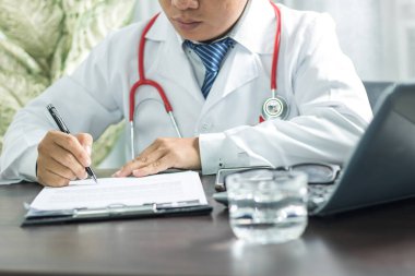 Working space of Doctor with stethoscope with medicine tablet and notebook for consult patient