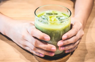 Buz matcha latte ahşap bir masa üzerinde.