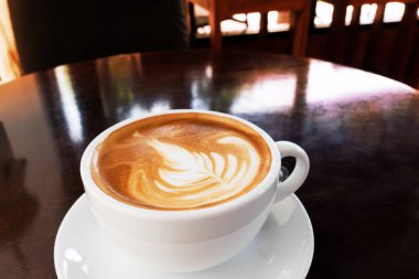 Ahşap bir masa üzerinde sıcak kahve Latte.