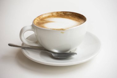 Sıcak latte sanat süt köpüğü bir kahve fincan beyaz bir tablo ile.