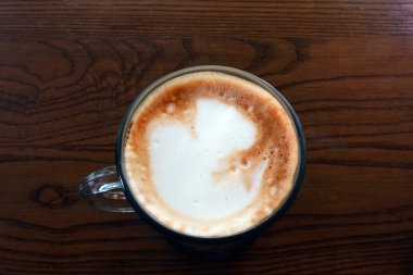  Ahşap bir masa üzerinde sıcak latte                              
