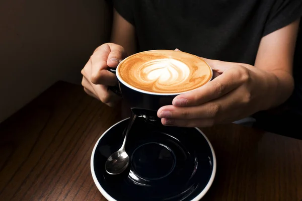 彼女の手でコーヒーのカフェラテ 暗い背景 — ストック写真