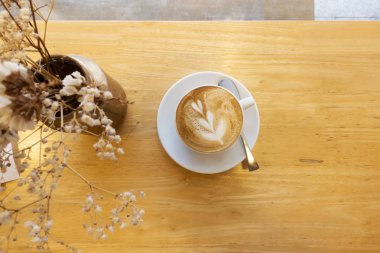 Ahşap bir masa üzerinde sıcak kahve sanatı.