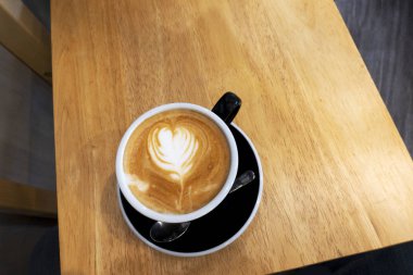 Ahşap bir masa üzerinde sıcak kahve Latte.