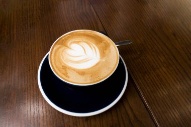 Latte kahve koyu ahşap masa üzerinde.