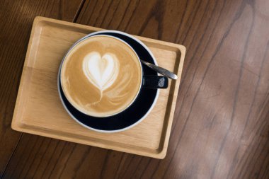 Tahta bir masada latte.