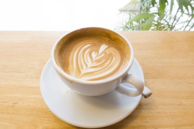 Ahşap bir masa üzerinde sıcak kahve Latte.