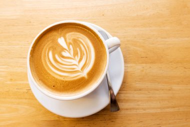 Ahşap bir masa üzerinde sıcak kahve Latte.