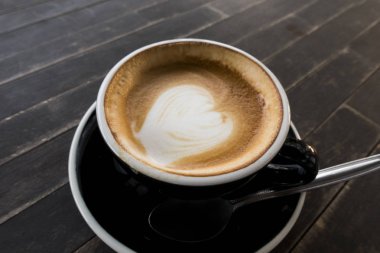 Tahta bir masada sıcak kahve fincanı..