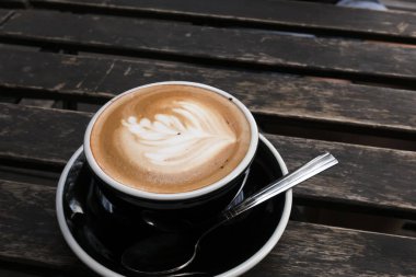 Eski ahşap masa üzerinde sıcak Latte