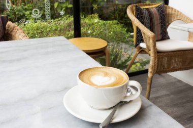 Mermer bir masada sıcak latte.
