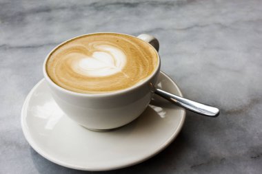 Mermer bir masada sıcak latte.