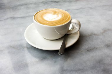 Mermer bir masada sıcak latte.