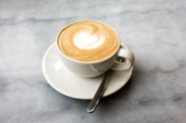 Mermer bir masada sıcak latte.